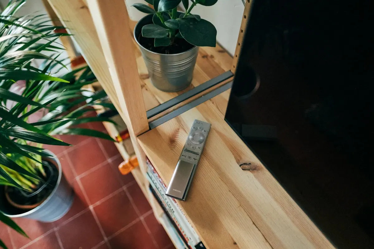 silver remote control on brown wooden table