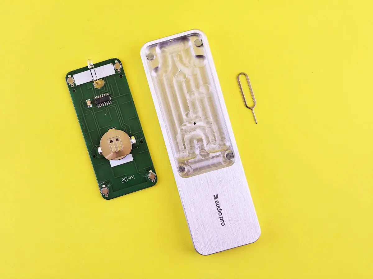 A cell phone is laying on a yellow surface