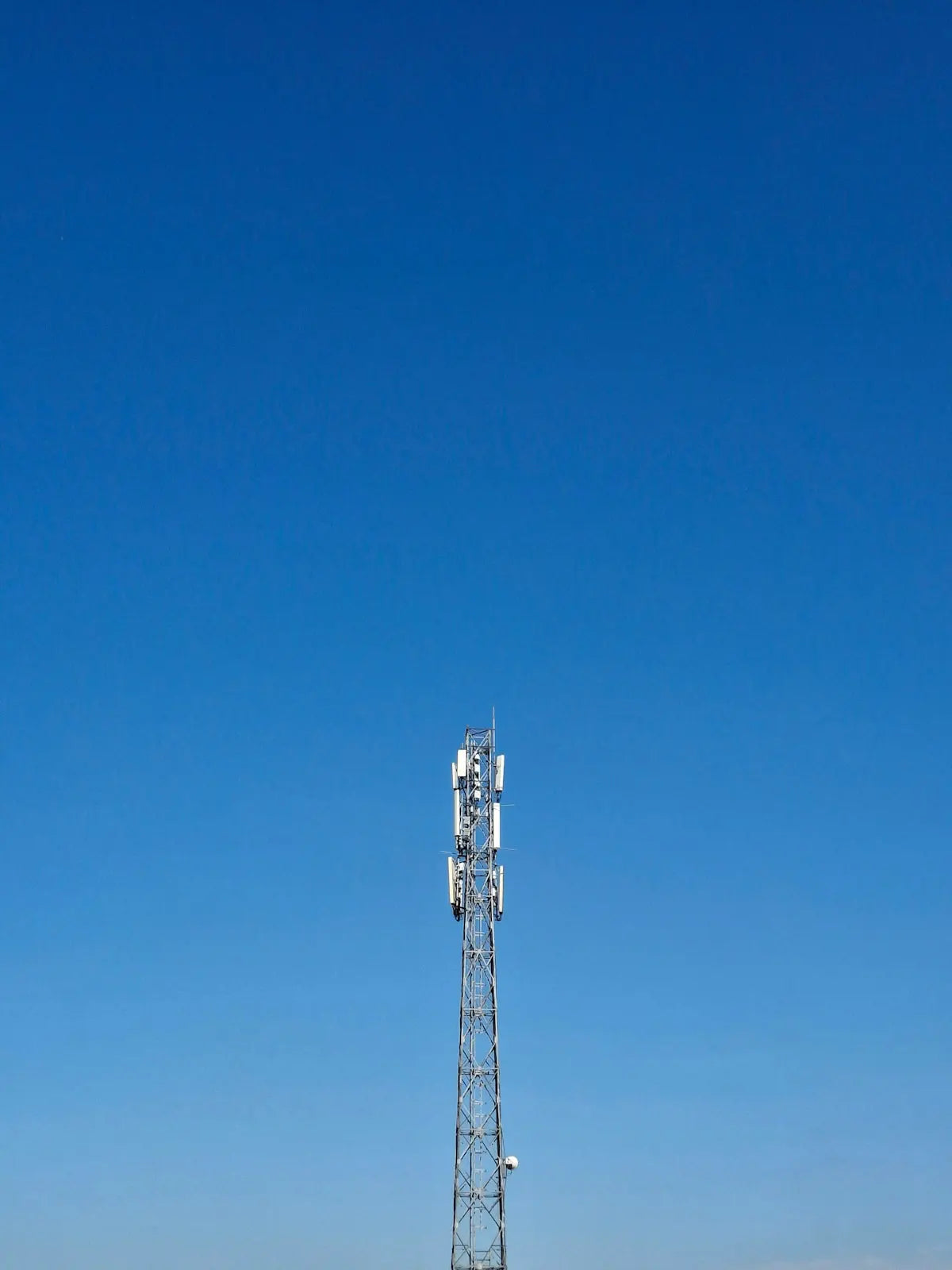 A tall communication tower stands against a blue sky.