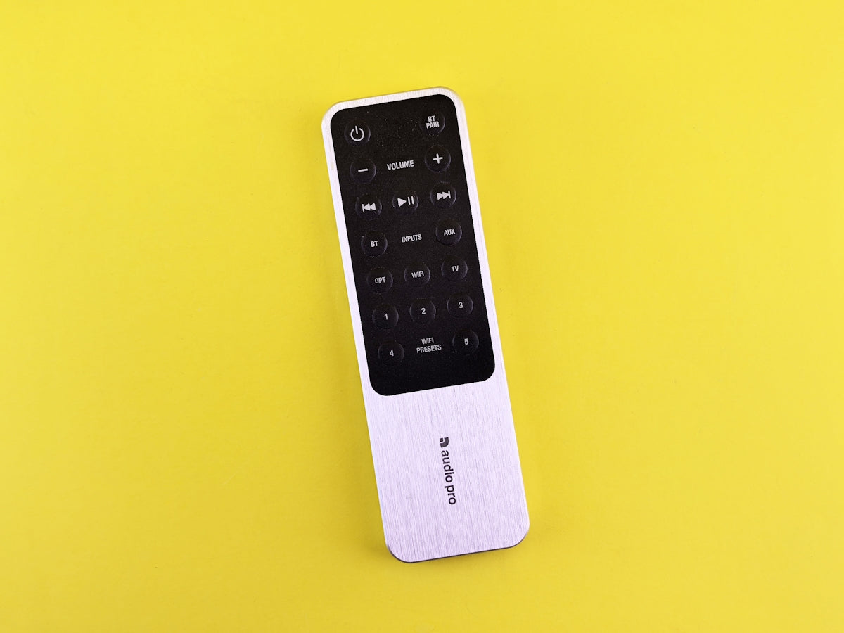 A remote control sitting on top of a yellow surface